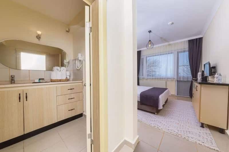 Kiraz-Hotel-Zimmer mit großem Einzelbett und großem Bett, seitlicher Meerblick